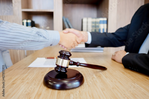 Lawyer consultant shaking hand with client in law firm