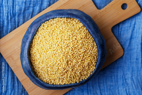 Millet or foxtail grains in bowl, top view photo