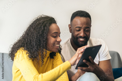 afro american couple watching tablet at home
