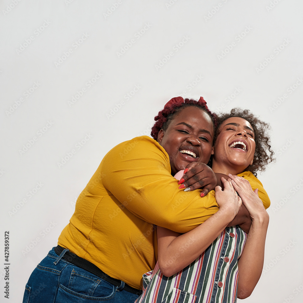 Obraz premium Two African women are having fan on camera hugging and laughing with teeth