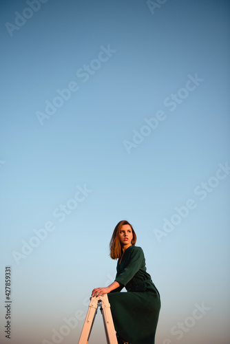 Woman standing on rooftop with blue sky on background