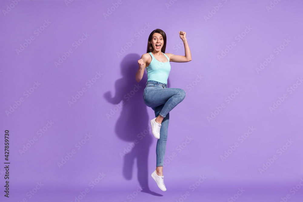 Full length body size photo of brunette jumping high gesturing like winner isolated on pastel purple color background