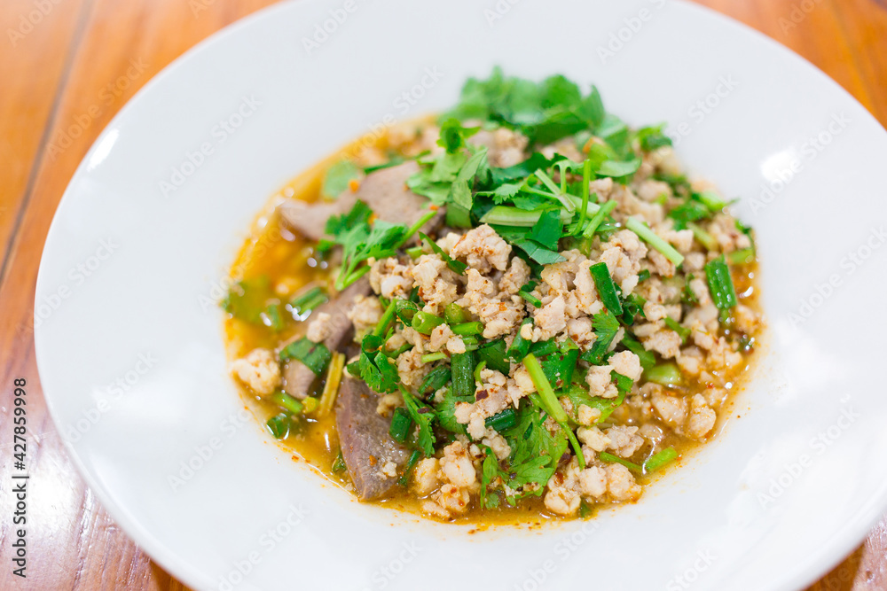 Spicy minced pork salad is traditional food of Northeast of Thailand. It contains minced pork, roasted rice, roasted chili and Thai herbs mixed together. It was put on white plate. Spicy minced pork salad is traditional food of Northeast of Thailand. It contains minced pork, roasted rice, roasted chili and Thai herbs mixed together. It was put on white plate.