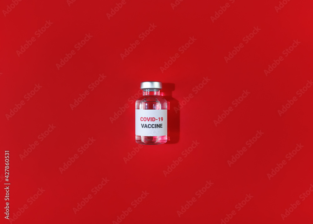 Vial with covid 19 vaccine on red background. Medical simple flat lay. Vial with covid 19 vaccine on red background. Medical simple flat lay.