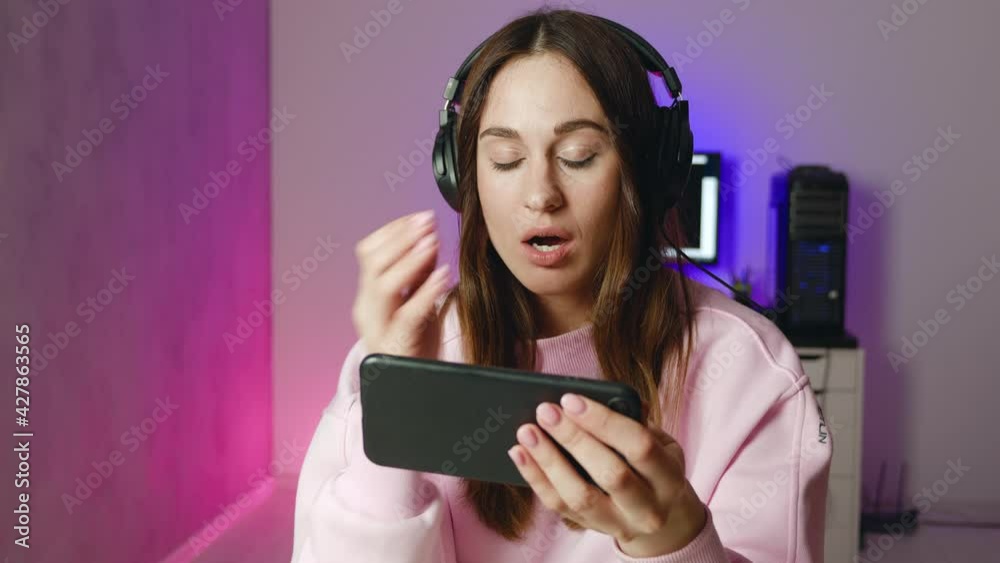 lifestyle young woman in headphones play game and is perplexed lifestyle young woman in headphones play game and is perplexed