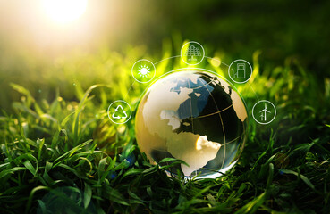 Crystal Globe  on grass at sunny background with Energy Resources icon. Earth day. Energy saving concept. Development Green Business Vnvestment