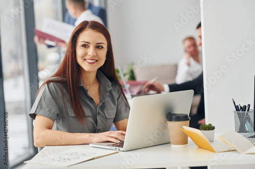 Woman with laptop. Group of people in official formal clothes that is indoors in the office