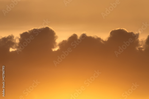 Beauty evening sky with warm cocoa color clouds, orange sunset. Natural abstract background. © Stepanov Aleksei