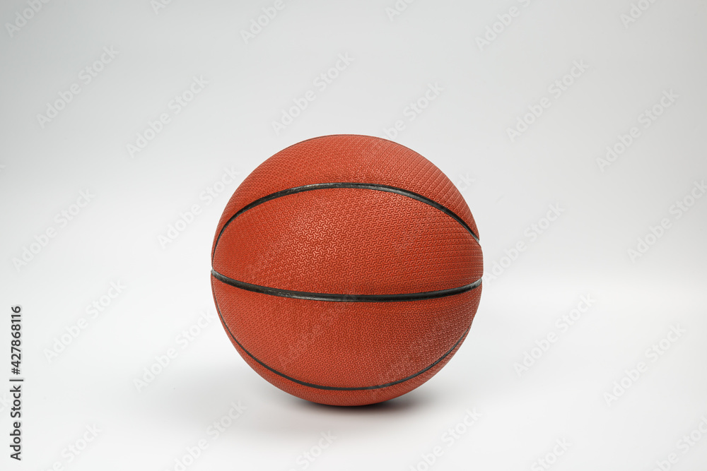 Basketball ball in hand. Hand holds a basketball. Hand trim basketball ball on white background. Basketball ball on a white background. 