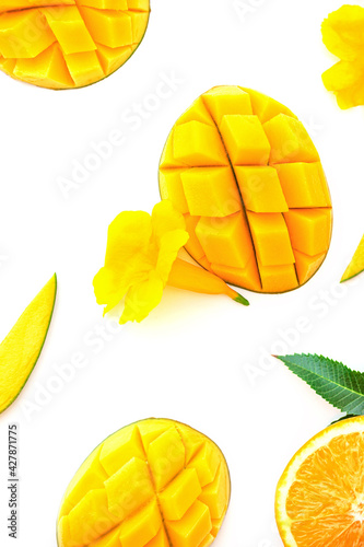 Ripe chopped mango on white with yellow flowers. Vegan beautiful dessert layout on white. Isolated image