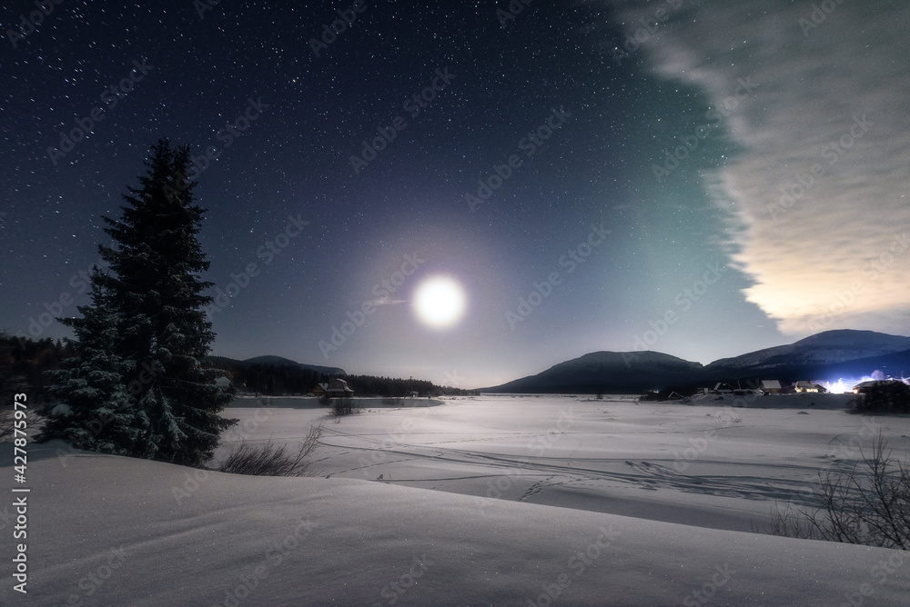 Nighttime winter landscape in the light of the full moon. Full moon in the polar region.