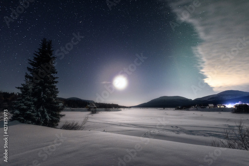 Nighttime winter landscape in the light of the full moon. Full moon in the polar region. © Andrei Baskevich