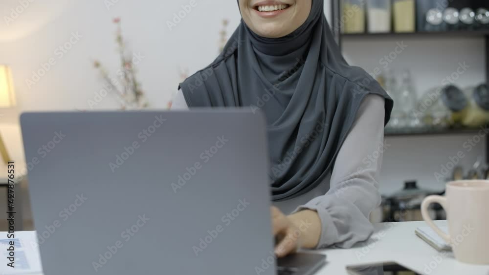 Cheerful arab woman in hijab finishing project and closing laptop, distance work Cheerful arab woman in hijab finishing project and closing laptop, distance work