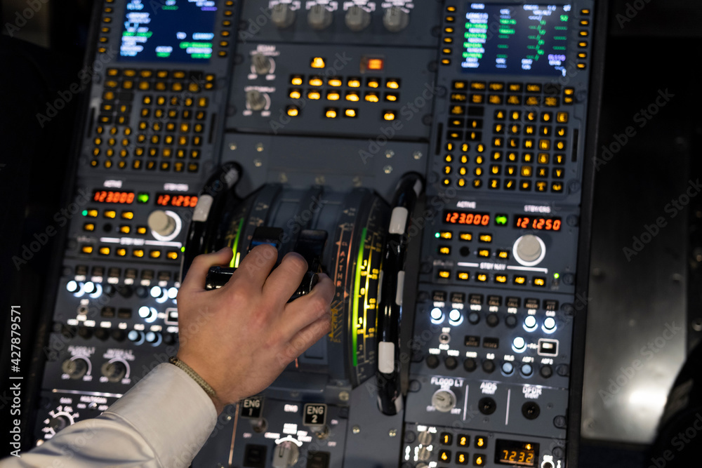 Naklejka premium Hand of a pilot activating the acceleration lever of a commercial flight simulator during a flight practice