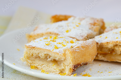 Lemon tart with filling, icing sugar and lemon zest