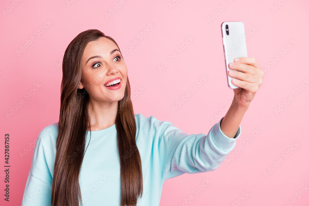 Photo of attractive beautiful amazed young woman hold phone take video selfie isolated on pastel shine pink color background