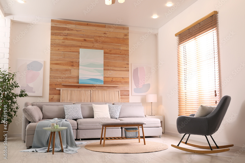 Fototapeta premium Stylish living room interior with comfortable sofa and pictures