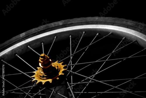 Old bicycle wheel with with selective color on black background. photo