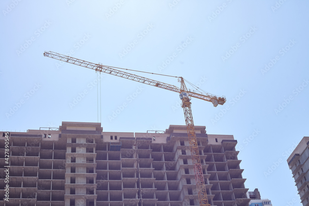 The process of building a multi-storey residential building. Construction crane The process of building a multi-storey residential building. Construction crane