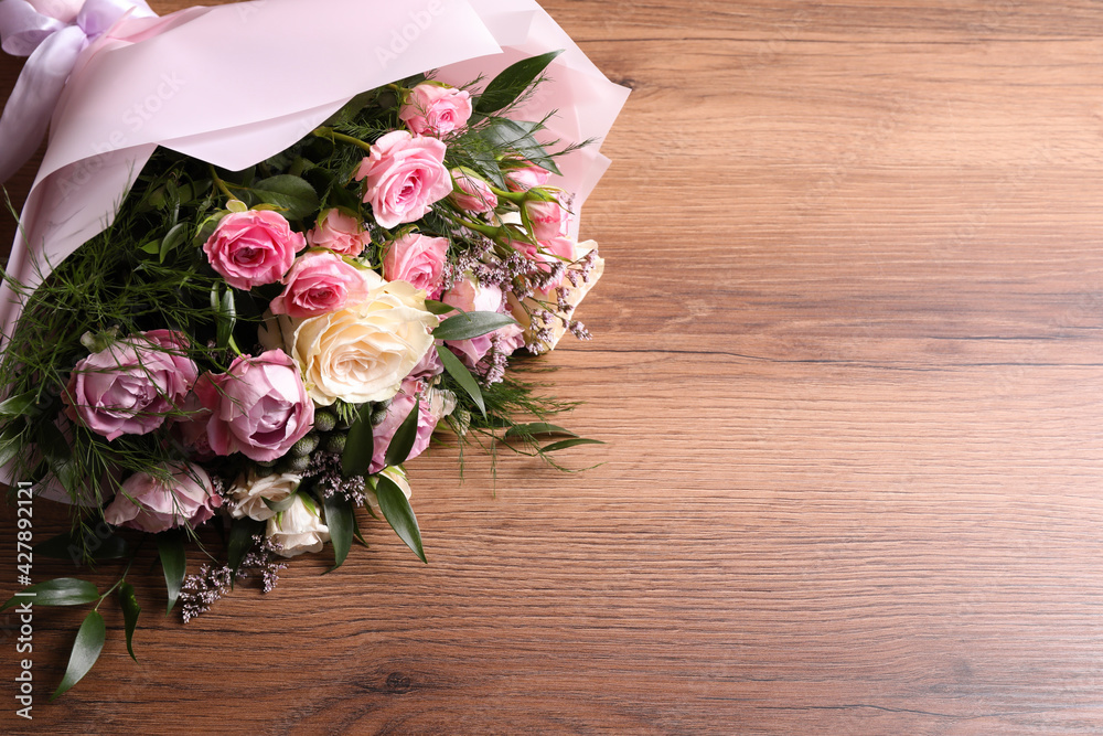 Beautiful bouquet with roses on wooden table. Space for text - obrazy, fototapety, plakaty 