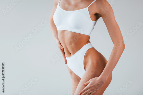 Particle view. Woman with sportive slim body type in underwear that is in the studio