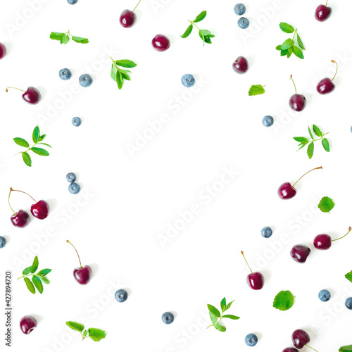 Cherry and blueberries with mint on white background. Top view. Flat lay frame with berries