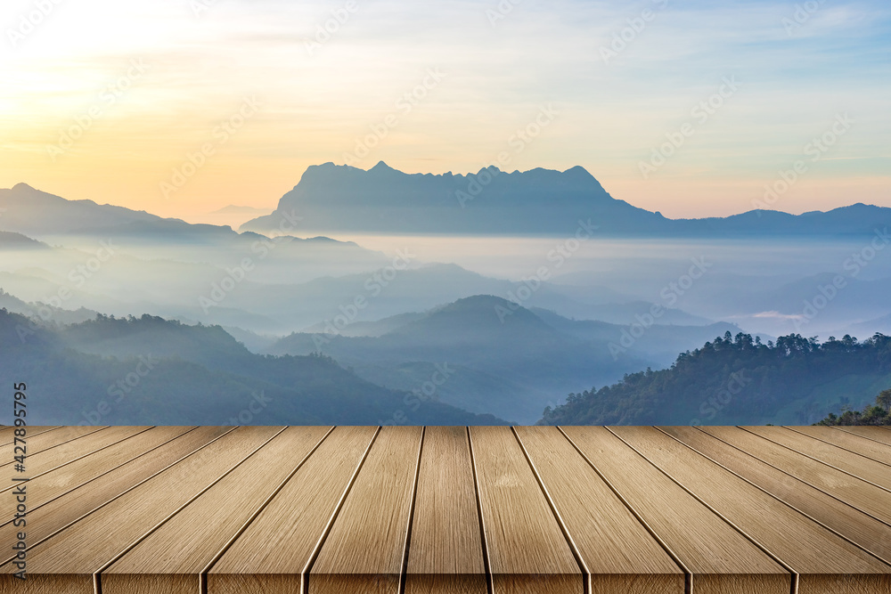Wooden table floor with mountain view and sunrise mist background