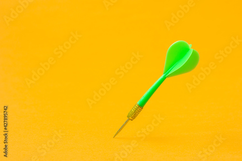 Green dart arrow on the yellow background