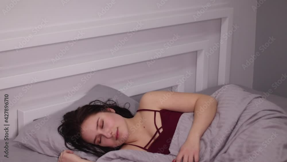 sensual beautiful brunette woman in a bed with gray sheets sleeping, having dreams and thinking. sensual beautiful brunette woman in a bed with gray sheets sleeping, having dreams and thinking.