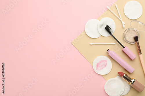Dirty cotton pads, swabs and cosmetic products on color background, flat lay. Space for text