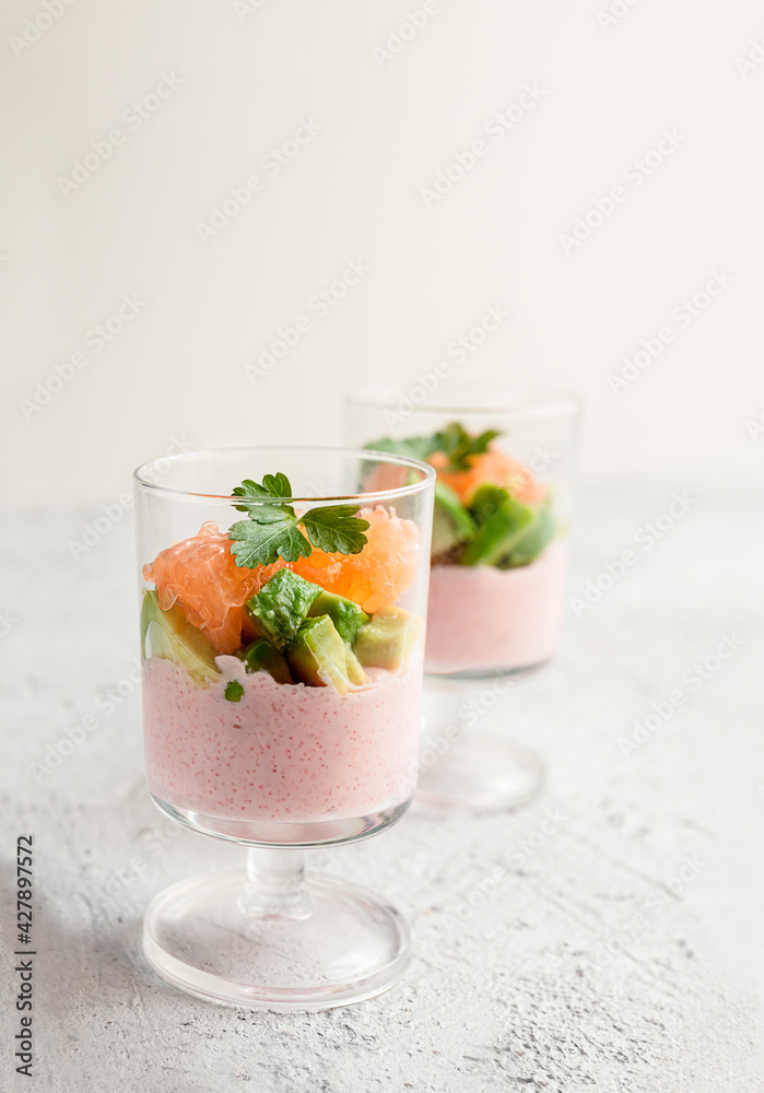 Tarama or taramasalata appetizer with avocado and pink grapefruit in glass cups on the light gray background close-up Tarama or taramasalata appetizer with avocado and pink grapefruit in glass cups on the light gray background close-up