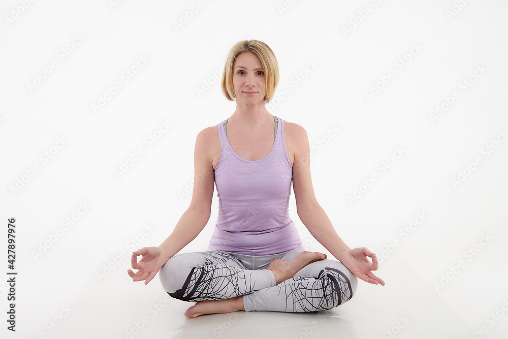 Girl doing yoga in a studio with a white background