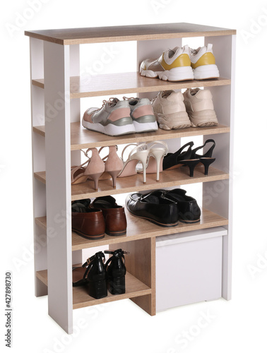 Stylish shelving unit with different pairs of shoes on white background. Storage idea