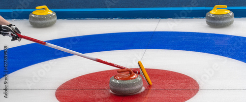 equipment for the game of curling. selective focus. granite stone and brush on ice