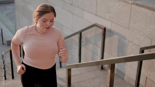 Wallpaper Mural Positive sportswoman climbing stairs outdoors, cardio training, body endurance Torontodigital.ca