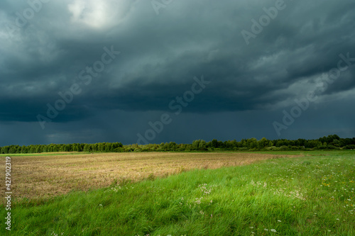 Beautiful fields and meadows and dark danger thundercloud