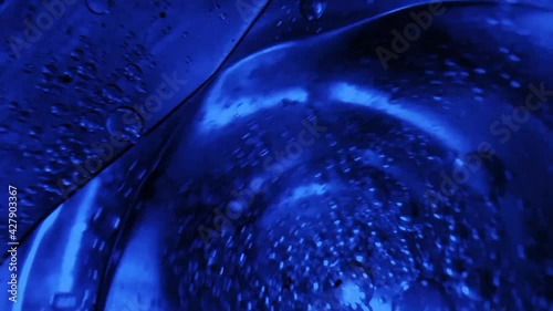 Motion blur liquid drop oil water blue concept.