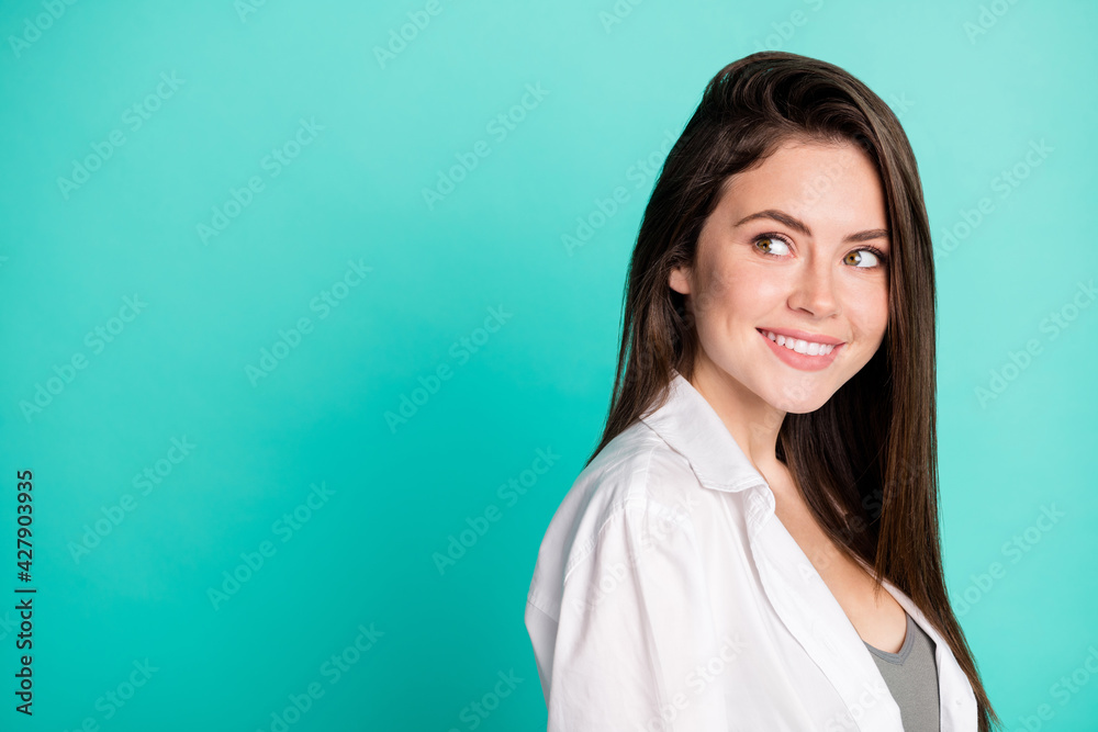Profile side photo of attractive lovely nice young woman look empty space smile isolated on pastel teal color background Profile side photo of attractive lovely nice young woman look empty space smile isolated on pastel teal color background