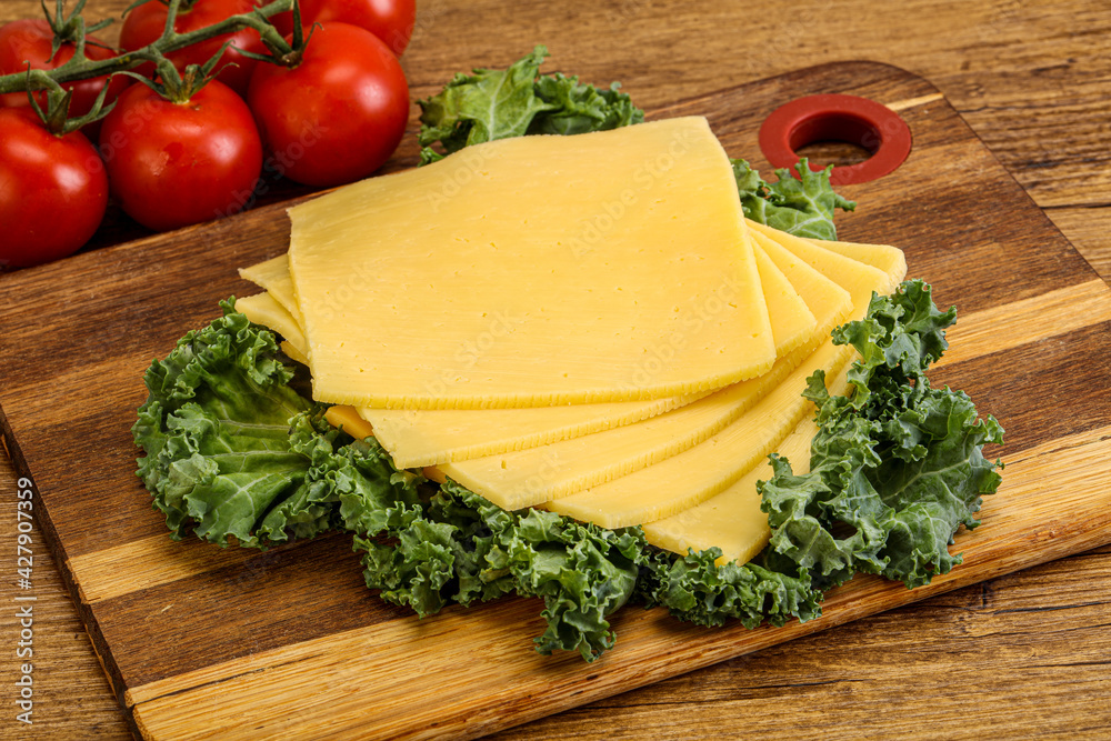 Sliced Gauda cheese over board Sliced Gauda cheese over board
