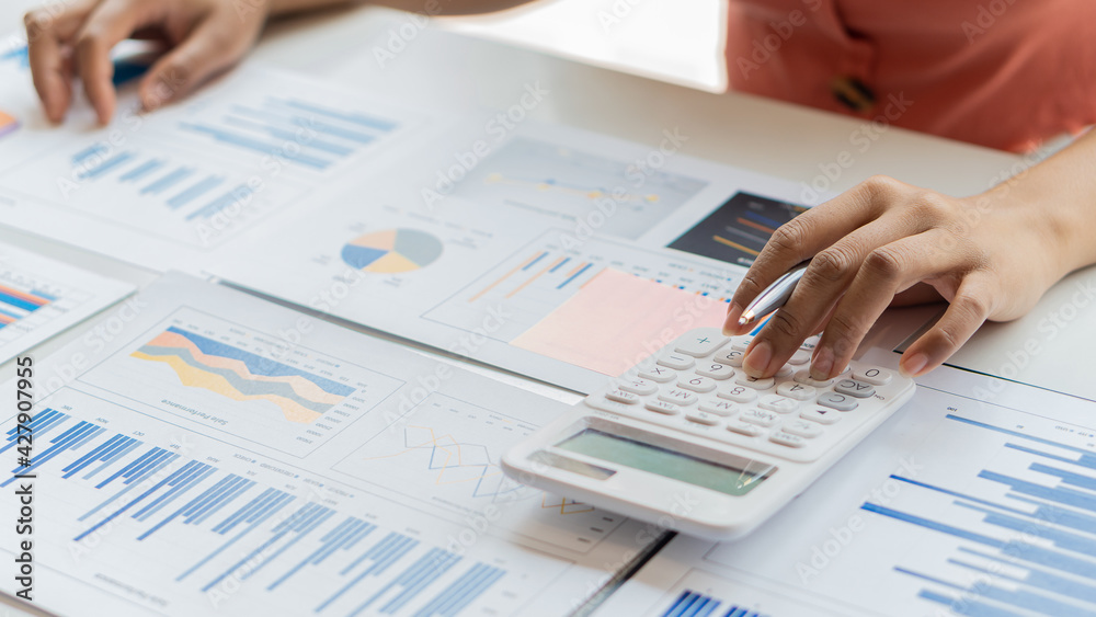 An accountant, businessman or finance professional analyzes graphs, business reports and financial charts at the Office of Financial Economics Concepts.