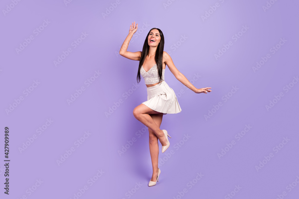 Full length photo of charming gorgeous young woman raise hand leg dance party isolated on violet color background