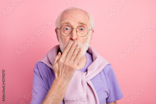 Photo portrait of elder man in glasses shut mouth keeping secret staring isolated on pastel pink color background