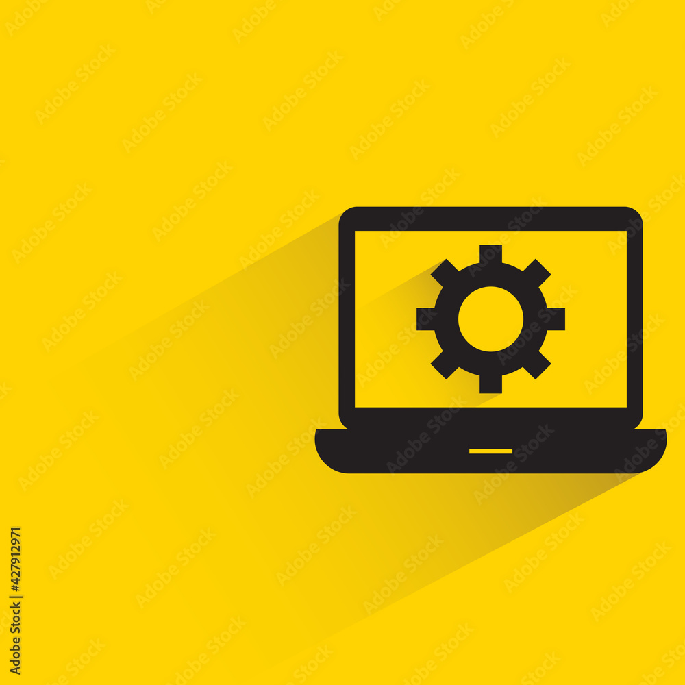 gear in laptop with shadow on yellow background gear in laptop with shadow on yellow background