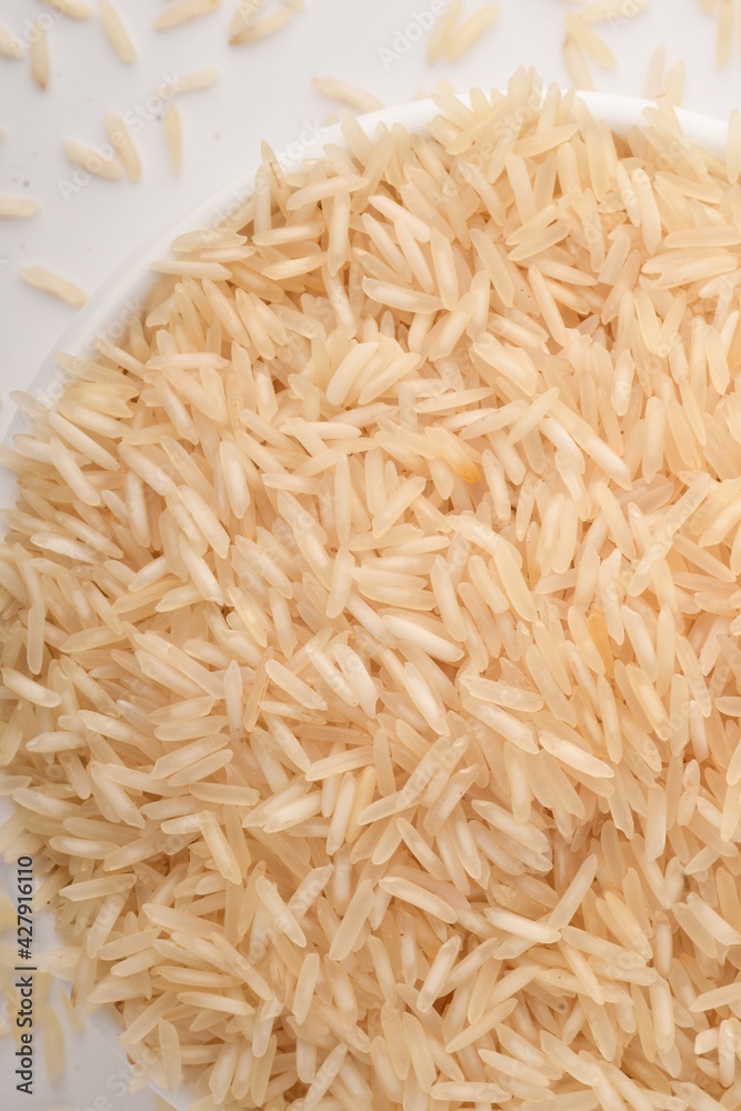 Fototapeta premium uncooked long brown rice isolated on white