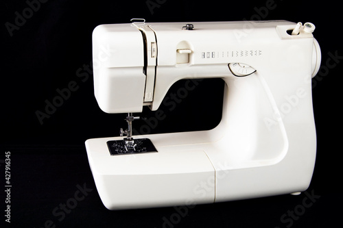 White automatic sewing machine on black background. © Александр Петухов