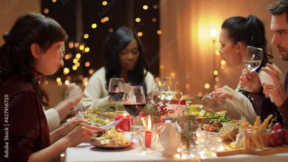 winter holidays, celebration and people concept - happy friends having christmas dinner at home winter holidays, celebration and people concept - happy friends having christmas dinner at home