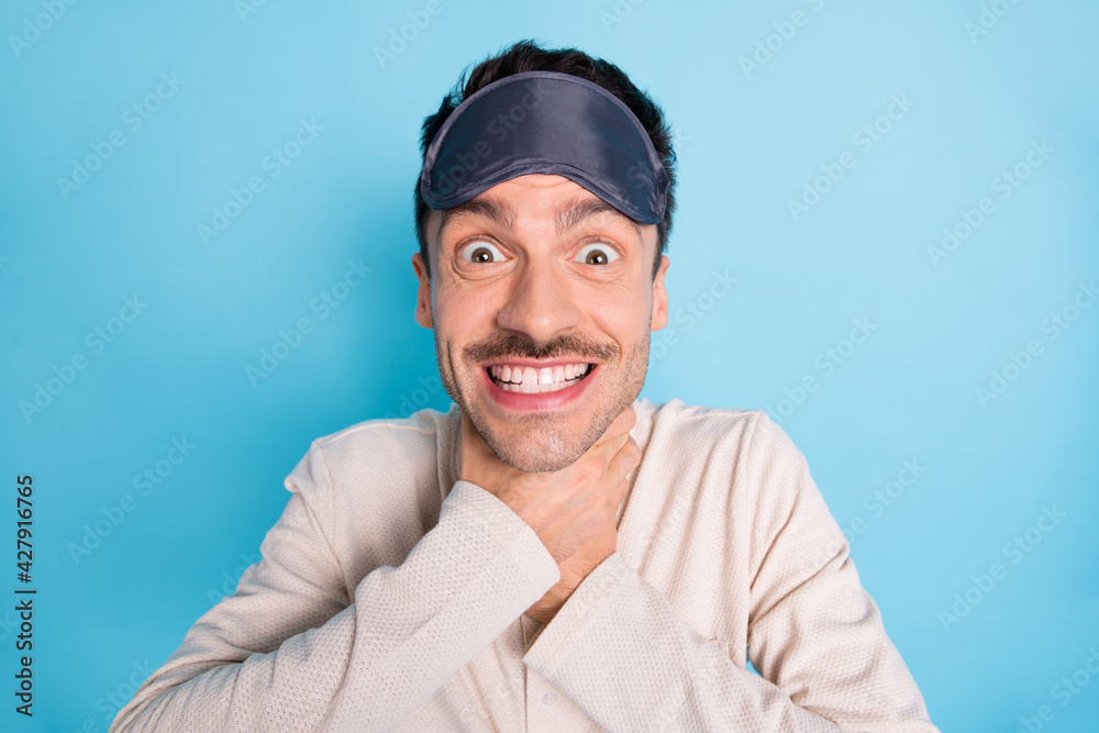 Portrait of nice cheerful funny brunet guy wearing sleep mask choking neck having fun isolated over bright blue color background Portrait of nice cheerful funny brunet guy wearing sleep mask choking neck having fun isolated over bright blue color background