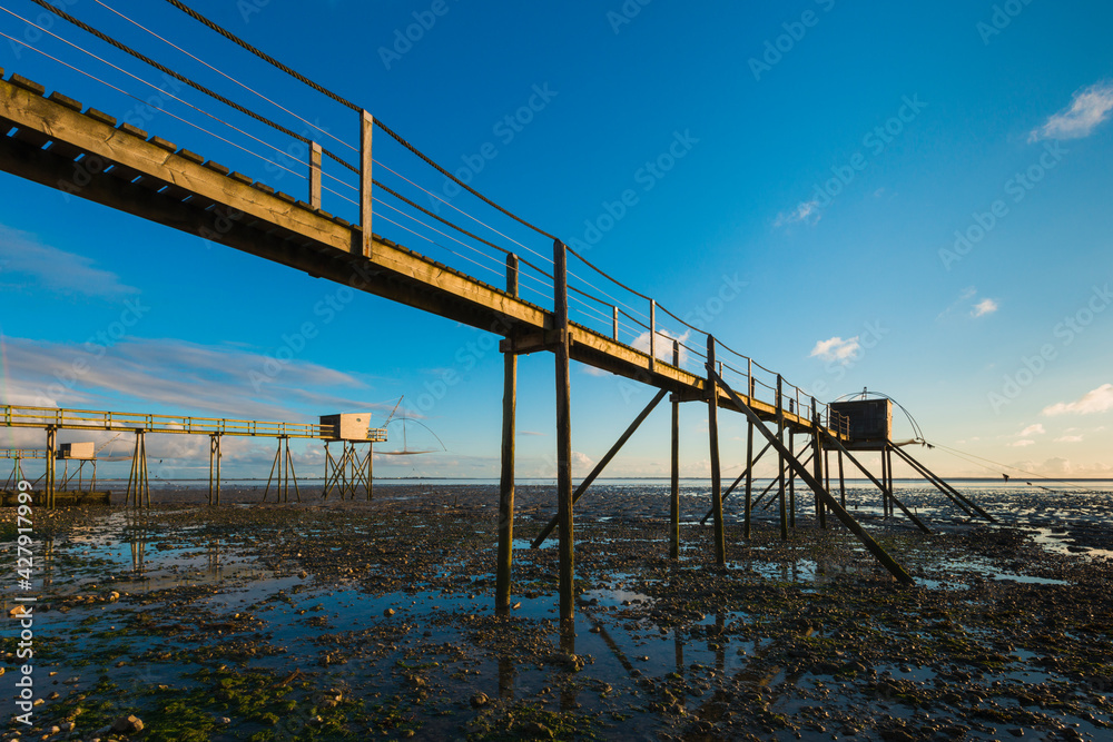 Obraz premium des carrelets ou pontons de peche à marée basse au soleil couchant