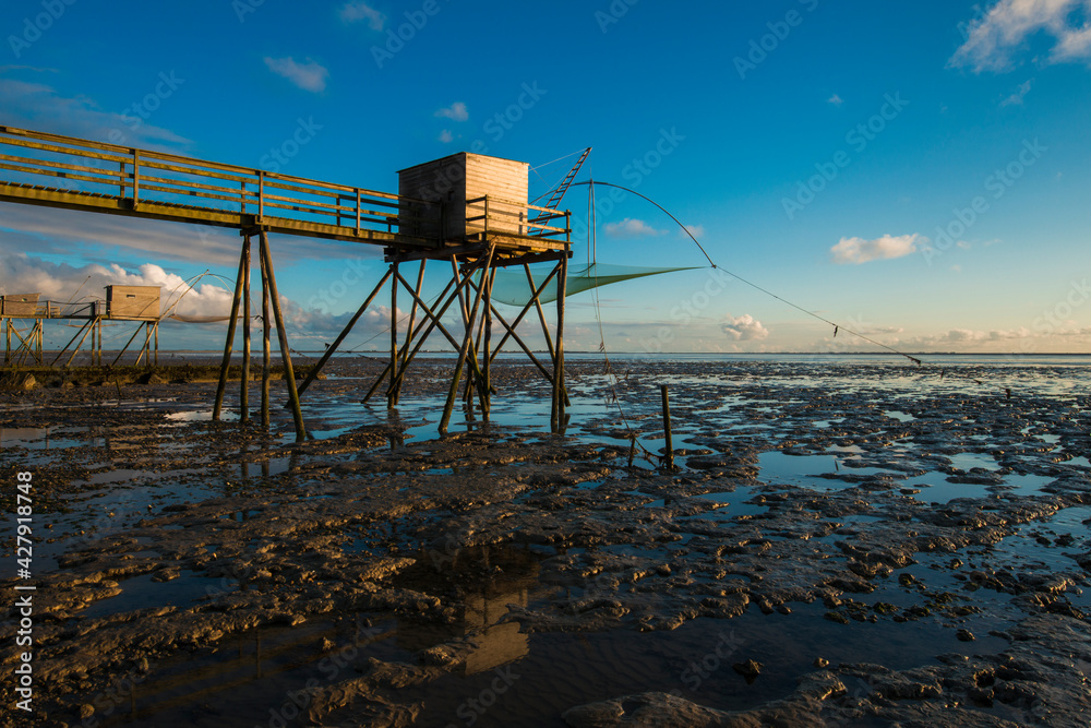 des pontons de peches ou carrelets au bord de l'ocean atlantique en Bretagne à marée basse et au soleil couchant des pontons de peches ou carrelets au bord de l'ocean atlantique en Bretagne à marée basse et au soleil couchant