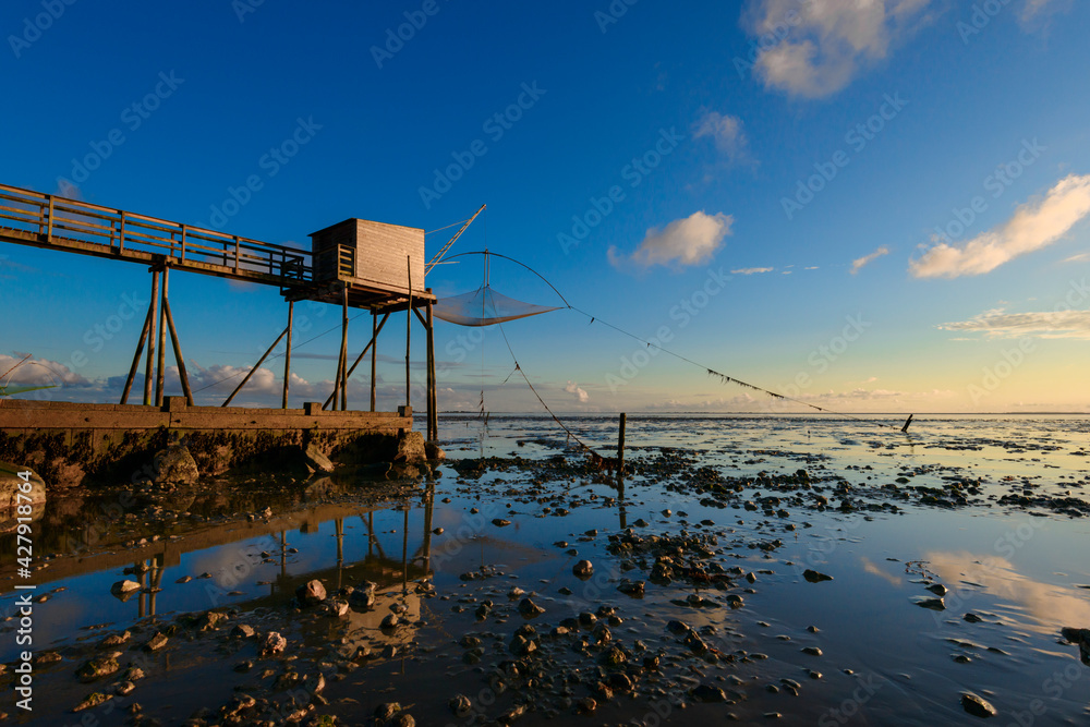 des pontons de peches ou carrelets au bord de l'ocean atlantique en Bretagne à marée basse et au soleil couchant